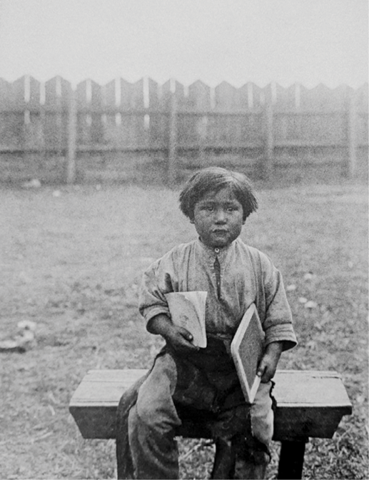 Imagen 4. Niño mapuche con cuaderno y pizarra.